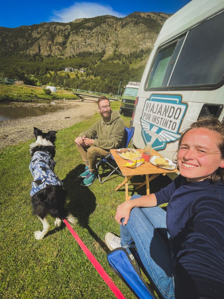 Pareja comiendo al sol en el camping municipal de Ushuaia en verano un dia soleado.